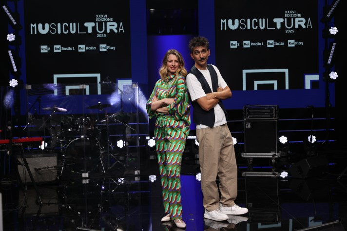 Immagine del Festival Musicultura 2025 a Macerata con il palco dello Sferisterio. In evidenza i vincitori del concorso e gli ospiti speciali come Riccardo Cocciante e Vinicio Capossela. L'evento celebra la canzone popolare e d'autore, con serate finali e premi in palio.